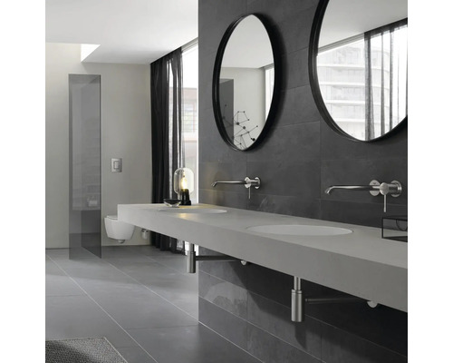 Moderná kúpeľňa s dvojitým umývadlom, okrúhlymi zrkadlami a sivou obkladovou stenou.