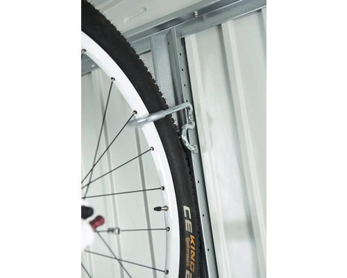 Záves na bicykel na kovovej stene s pneumatikou