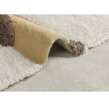 Detailný pohľad na koberec s geometrickým vzorom a tkaninou s vysokým vlasom