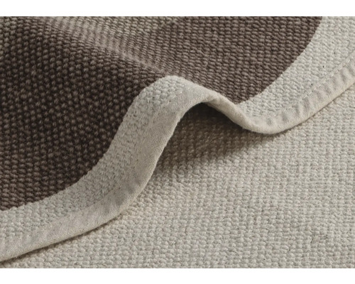 Detailný pohľad na béžový a hnedý kúpeľňový koberec