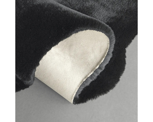 Čierny koberec s ohnutým rohom na zobrazenie zadnej strany