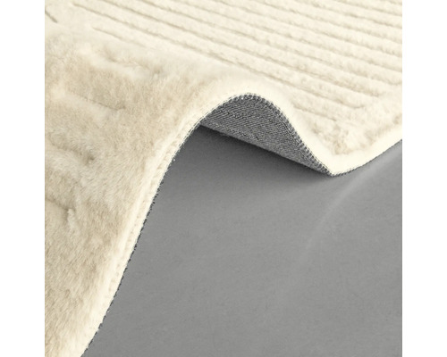 Béžový koberec s tkanou textúrou a ohrnutým okrajom