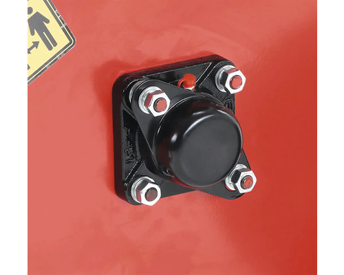 Detailný záber čierneho krytu pripevneného skrutkami k červenému povrchu