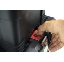 Detailný pohľad na kufor na náradie s červeným uzáverom ovládaným rukou.