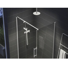 Sprchovací kút so sklenenými dverami, sprchovou hlavicou a ohrievačom uterákov v kúpeľni s tmavými dlaždicami