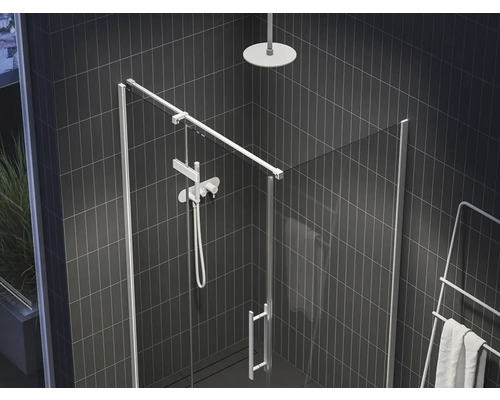 Sprchovací kút so sklenenými dverami, sprchovou hlavicou a ohrievačom uterákov v kúpeľni s tmavými dlaždicami