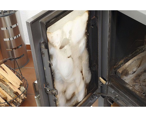 Otvorené dvierka kachlí s izoláciou a košom na drevo