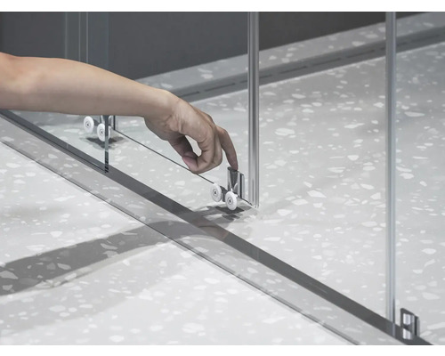 Detail sprchovacieho kúta s posuvnými dverami a valčekovým mechanizmom.