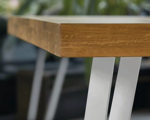 Detailný pohľad na drevenú stolovú dosku s kovovými nohami