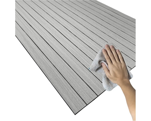 Osoba čistí podlahovú krytinu s dreveným vzhľadom handričkou