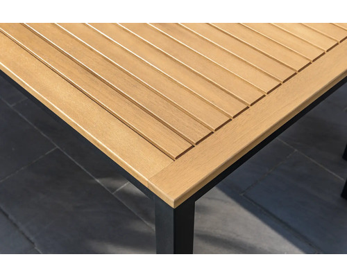 Detailný pohľad na drevenú dosku záhradného stola s čiernym rámom stola.