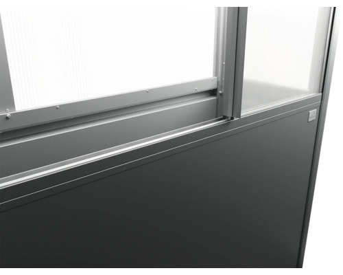 Detailný pohľad na rám skleníka so sklenenými panelmi a sivou základňou