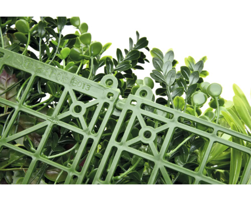 Umelá rastlinná stena so zelenými listami a plastovou mriežkou