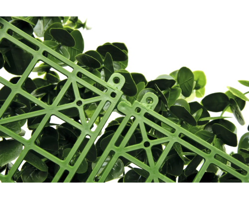 Detailný záber zelenej rastlinnej rohože s plastovou mriežkou