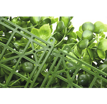 Detailný pohľad na umelý rastlinný panel so zelenými listami a plastovou mriežkou