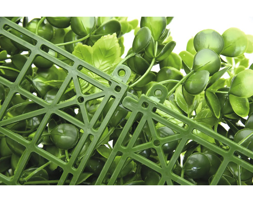 Detailný pohľad na umelý rastlinný panel so zelenými listami a plastovou mriežkou