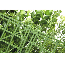 Detailný záber umelého živého plota s plastovou mriežkou na zadnej strane.