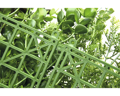 Detailný záber umelého živého plota s plastovou mriežkou na zadnej strane.