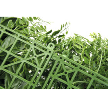 Detailný pohľad na umelý živý plot so zelenými listami a plastovou mriežkou