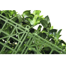 Detail umelého živého plota s listami a mriežkovou štruktúrou