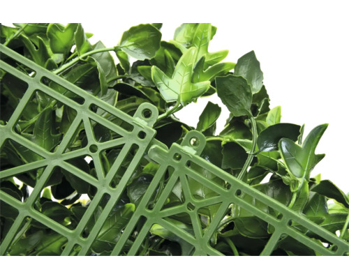 Detail umelého živého plota s listami a mriežkovou štruktúrou