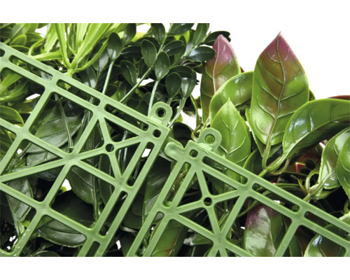 Detailný záber umelého živého plota so zelenými listami a zelenou plastovou mriežkou