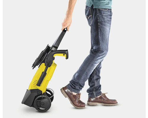 Osoba ťahá žltý vysokotlakový čistič.