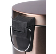 Detailný záber kovového odpadkového koša s pedálovým mechanizmom.