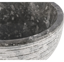 Detailný záber sivej kamennej kvetinovej misy s ryhovaným povrchom.