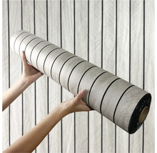 Rola vinylovej podlahy držaná dvoma rukami.