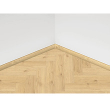 Roh s laminátovou podlahou vo vzore rybej kosti a štvrťkruhovou rohovou lištou na stene.