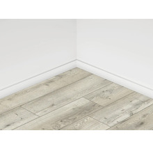 Rohový pohľad na miestnosť so svetlou laminátovou podlahou v drevenom vzhľade a bielymi stenami