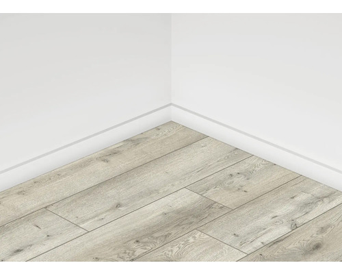 Rohový pohľad na miestnosť so svetlou laminátovou podlahou v drevenom vzhľade a bielymi stenami