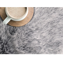 Sivý koberec s vysokým vlasom a šálka