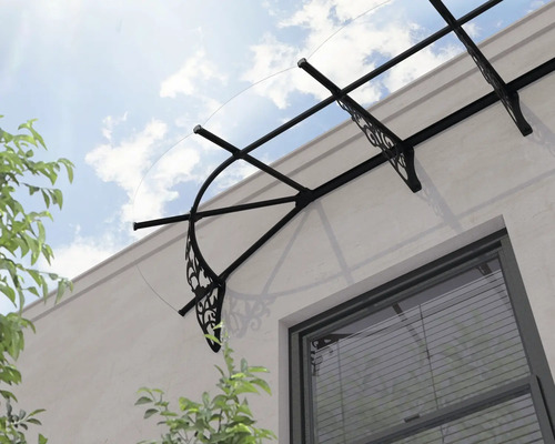 Strieška nad vchod s priehľadnou krytinou a ozdobnými čiernymi kovovými držiakmi nad oknom.