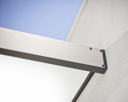 Detailný pohľad na hliníkový nosník zastrešenia terasy pripevnený skrutkami k vonkajšej stene.