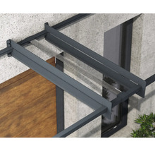 Detail vchodovej striešky s antracitovým hliníkovým rámom a priehľadnou sklenenou výplňou na fasáde domu.