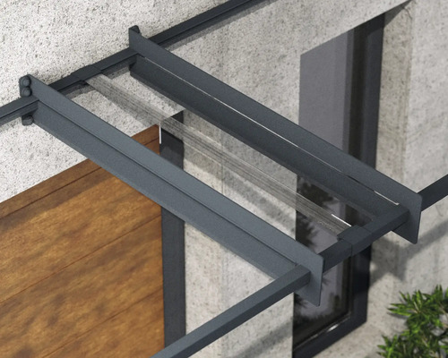 Detail vchodovej striešky s antracitovým hliníkovým rámom a priehľadnou sklenenou výplňou na fasáde domu.