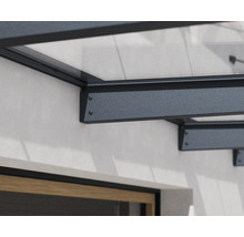 Detail nástenného upevnenia zastrešenia z hliníka a skla.