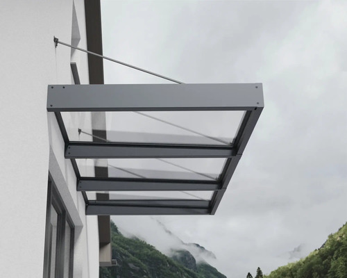 Moderná sklenená strieška s antracitovým hliníkovým rámom, namontovaná na vonkajšej stene pomocou tiahla.