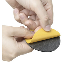 Osoba odstraňuje ochrannú fóliu z okrúhleho nábytkového klzáka