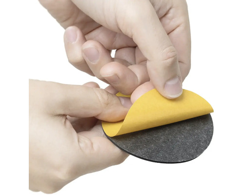 Osoba odstraňuje ochrannú fóliu z okrúhleho nábytkového klzáka