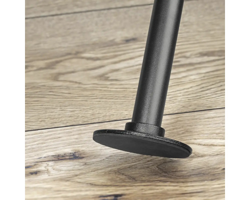 Detailný záber čiernej nohy nábytku s pätkou na drevenej podlahe.