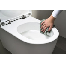 Osoba čistí bielu závesnú toaletu handričkou.