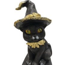 Dekoratívna čierna mačacia figúrka s čarodejníckym klobúkom a obojkom ako halloweenska dekorácia