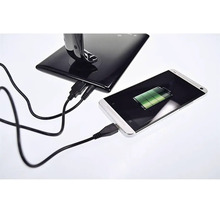 Smartfón sa nabíja pomocou USB kábla v nabíjacej stanici.