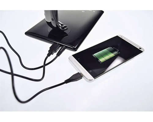 Smartfón sa nabíja pomocou USB kábla v nabíjacej stanici.