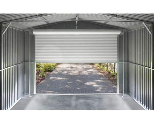 Vnútorný pohľad na kovový domček na náradie so stenami z vlnitého plechu a pootvorenou rolovacou bránou s výhľadom na dláždenú cestu.