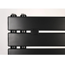 Detailný záber na matný čierny radiátor s plochými panelmi a vertikálnymi prípojkami.