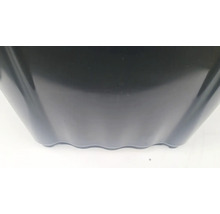 Detailný pohľad na čierny plastový kvetináč s vlnitým spodným okrajom.